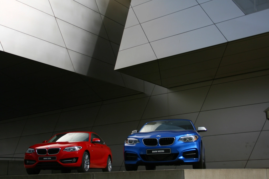 Zwei BMW Coupés vor einer Gebäudefassade